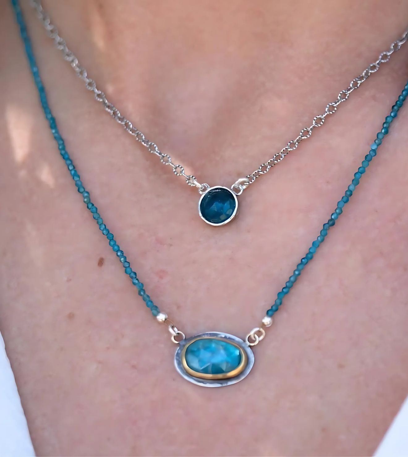 Layered look featuring the Amalfi Necklace with a faceted blue gemstone and the Pixie Necklace with delicate sterling silver details, highlighting nature-inspired elegance.