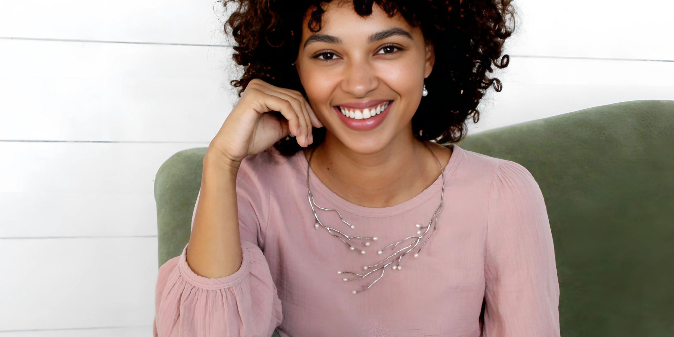 Model showcasing jewelry from the Haven Collection, featuring a hand-crafted sterling silver necklace with organic nature-inspired elements, styled with a soft pink blouse.