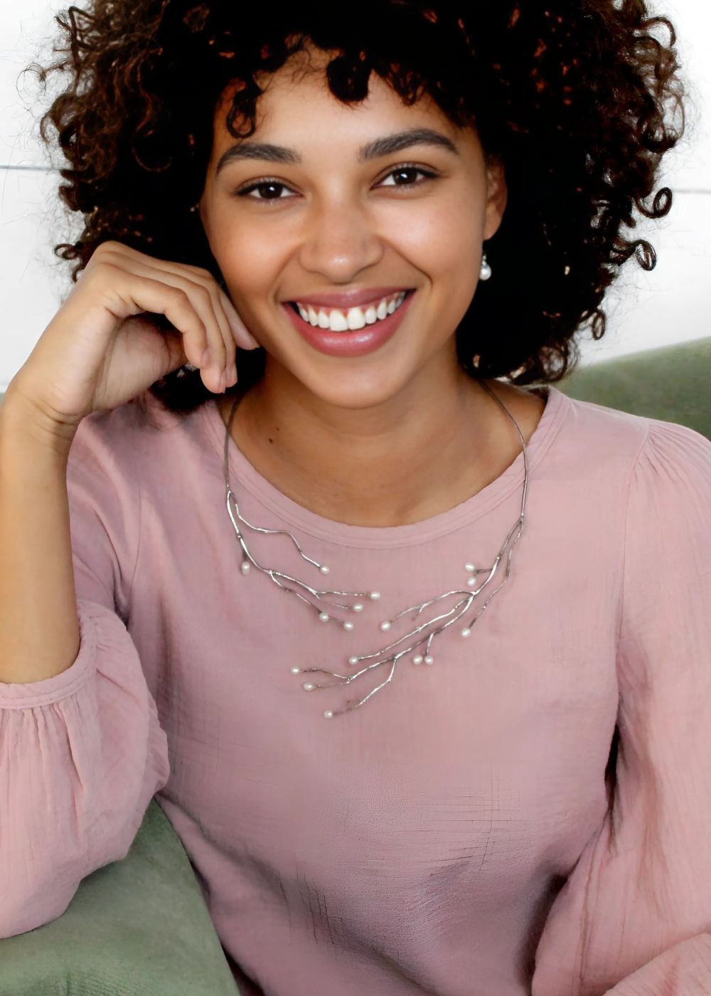 Model wearing jewelry from the Haven Collection, featuring a hand-crafted sterling silver necklace with branch-like details and delicate pearl accents, inspired by nature’s organic forms.